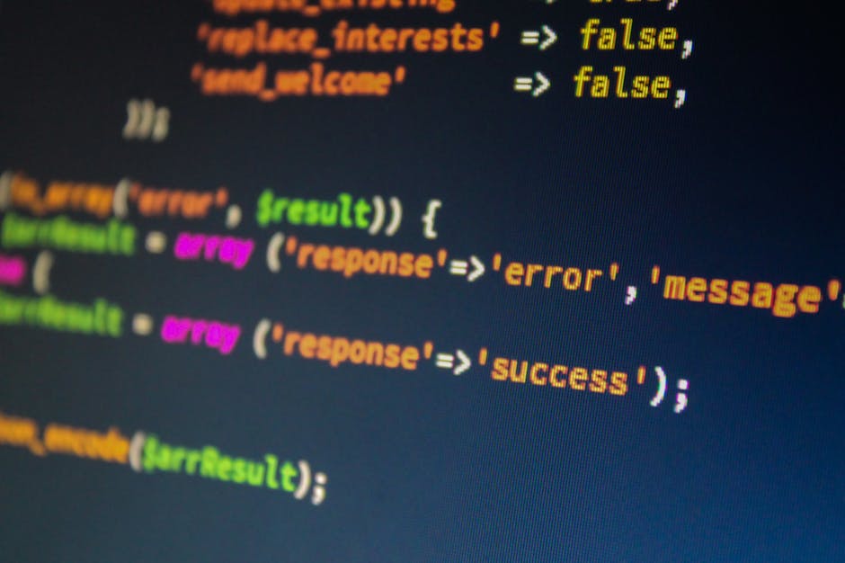 Close-up image of a computer monitor displaying multicolored lines of programming code on a dark background, illustrating common errors like 'false' and 'error' within a coding environment. The scene 